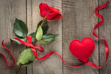 Sevgililer günü kartı. Ahşap tahta üzerinde kırmızı gül şerit ve kalp ile. Üstten Görünüm.