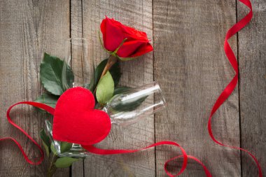 Sevgililer günü kartı. Kırmızı gül ve ahşap tahta üzerinde iki bardağı. Üstten Görünüm.