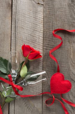 Sevgililer günü kartı. Kırmızı gül ve ahşap tahta üzerinde iki bardağı. Üstten Görünüm.