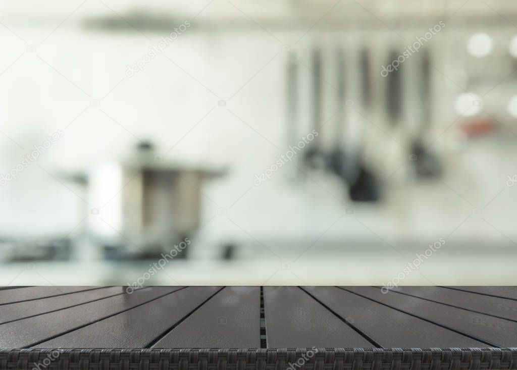 Blurred and abstract background. Empty wooden tabletop and defocused modern kitchen background for display or montage your products.