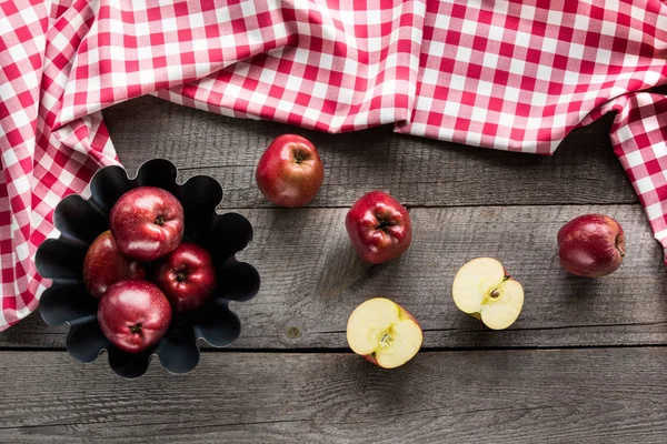 Manzanas rojas maduras en forma de hornear sobre tabla de madera con servilleta a cuadros roja . — Foto de Stock