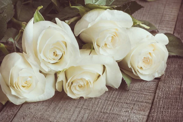 Zachte volledige geblazen witte rozen als een neutrale achtergrond op houten bord. Selectieve aandacht. Getinte afbeelding. — Stockfoto