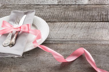 Elegance Tablo ayarı pembe kurdele ile ahşap tahta üzerinde romantik akşam yemeği. Rustik stile. Yakın çekim.