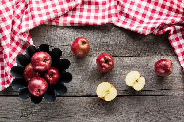 Manzanas rojas maduras en forma de hornear sobre tabla de madera con servilleta a cuadros roja . — Foto de Stock