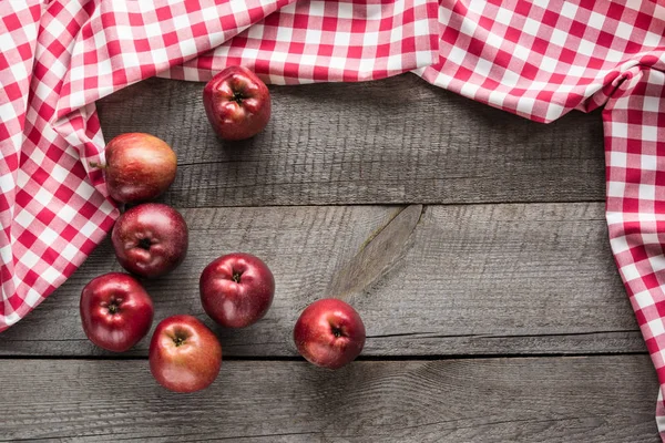Manzanas rojas maduras en tablero de madera con servilleta a cuadros roja alrededor y espacio de copia . — Foto de Stock