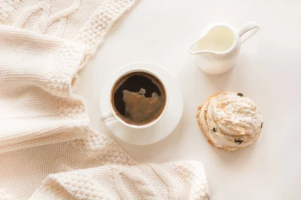 朝の朝食、牛乳、白地に暖かい穏やかなスカーフとパステル カラーのペストリー、ブラック コーヒーのカップ。トップ ビュー. — ストック写真