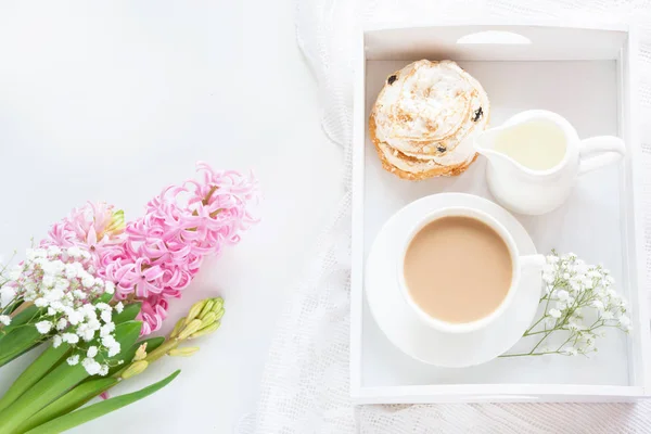 Morning romance breakfast, cup of coffee, milk jug and cake with decor of pink hyacinth. Spring concept. Top view. — Stock Photo, Image