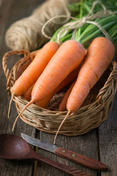 Zanahorias orgánicas frescas con tapas verdes en cesta sobre mesa de madera, primer plano. Copiar espacio . — Foto de Stock