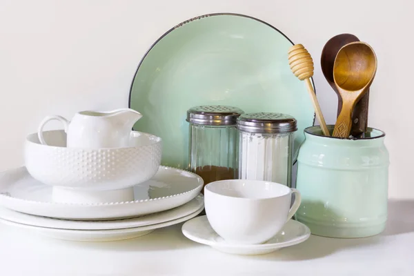 Посуд, посуд, посуд та інші різні білі та бірюзові речі на білому столі. Кухонне натюрморт як фон для дизайну. Зображення з простором копіювання . — стокове фото