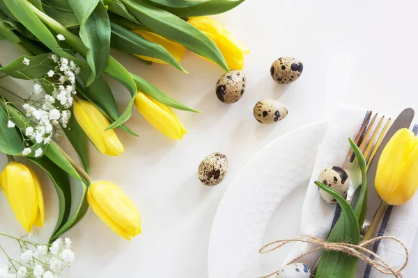 Concept de Pâques avec espace de copie pour vos vœux de Pâques heureux. Lieu de Pâques décoratif avec tulipe jaune, un oeuf de caille sur fond blanc . — Photo