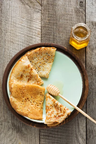 Geleneksel Rus kahvaltıyla krep tabakta bal ile. Rustik tarzı. Senin metin için yer.