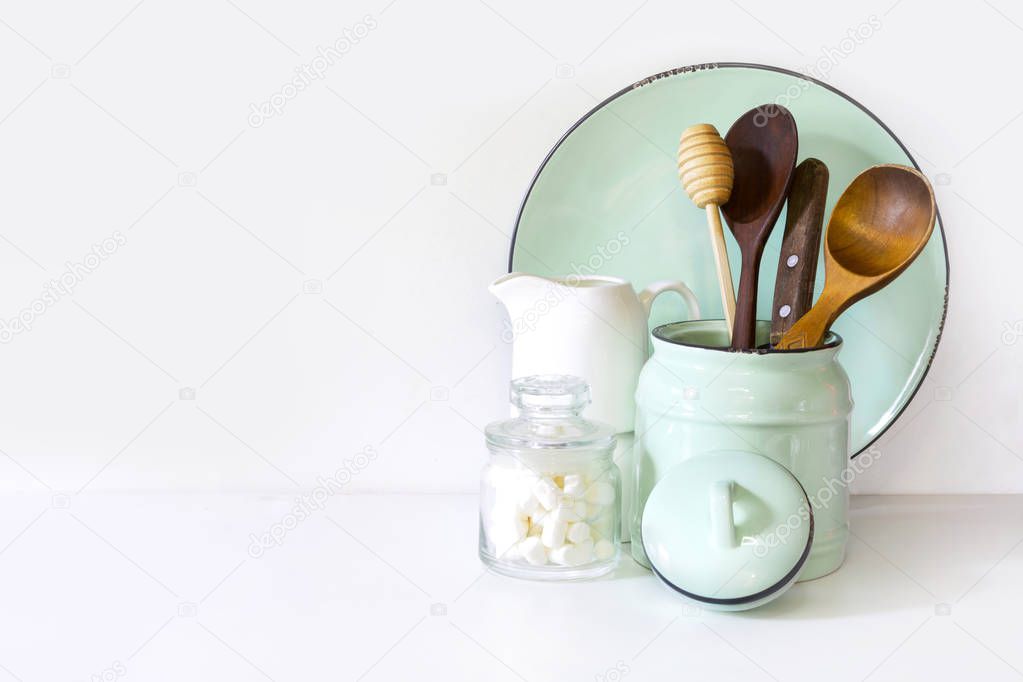 Crockery, tableware, utensils and other different white and turquoise stuff on white table-top. Kitchen still life as background for design. Image with copy space.