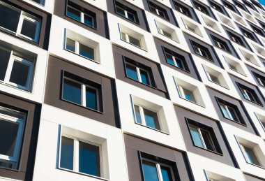 Modern ve yeni apartman. Fotoğraf mavi gökyüzü karşı Balkonlu daireler uzun boylu bir blok.