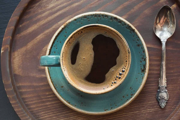 Чашка чорної кави з ложкою кави на дерев'яному підносі . — стокове фото