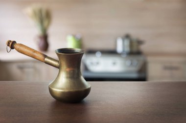 Ahşap masa ve ufuk modern mutfak için arka plan olarak siyah kahve ile Vintage bakır cezve görüntülemek veya kahve ürün montaj.