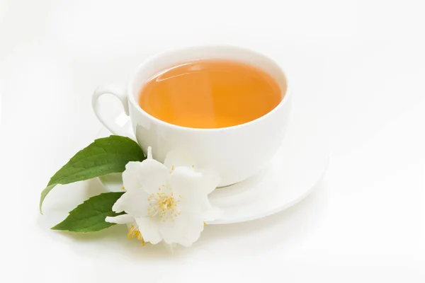 Flores de jasmim e xícara de chá verde em branco. Vista lateral e conceito . — Fotografia de Stock