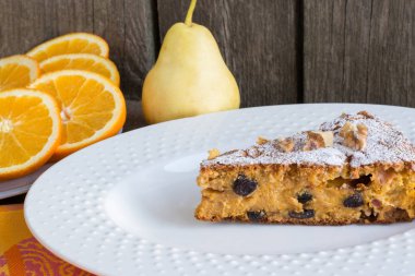 Lezzetli havuçlu kek gelen fındık, Kuru üzüm Orange, dekor ile armut beyaz tabakta. Rustik tarzı.