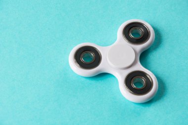 Beyaz parmak spinner stres, anksiyete Rölyef oyuncak kıpır. Düz mavi üzerinde yatıyordu