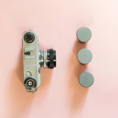 Eski retro fotoğraf makinesi ile üç kutu pembe bir arka plan üzerinde film için.