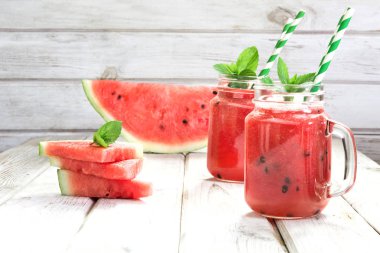 Detoks yüzlü karpuz ve nane Beyaz ahşap zemin üzerinde serinletici yaz.