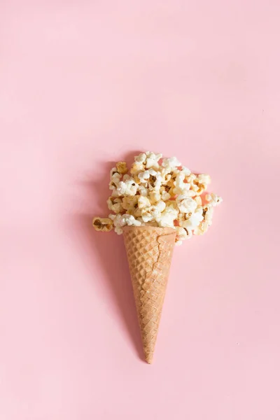Popcorn in ice cream cones on pink background. Top view. — Stock Photo, Image