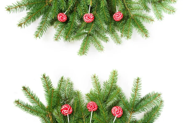 Ramas de árbol de Navidad y piruleta roja sobre un fondo blanco. Vista desde arriba . — Foto de Stock
