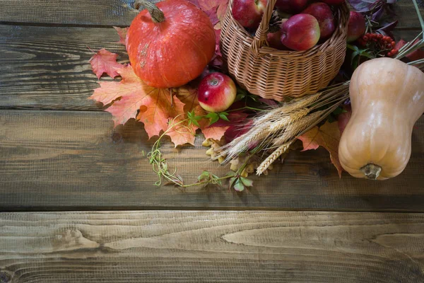 Herbsternte, Kürbis, Äpfel im Korb, buntes Herbstlaub auf Holzbrettern. Kopierraum. Ansicht von oben. — Stockfoto