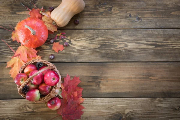 Φθινοπωρινή συγκομιδή, κολοκύθα, τα μήλα στο καλάθι, πολύχρωμα φύλλα του φθινοπώρου σε ξύλινη σανίδα. Φθινόπωρο, αντιγράψτε το χώρο. Το Top view. — Φωτογραφία Αρχείου
