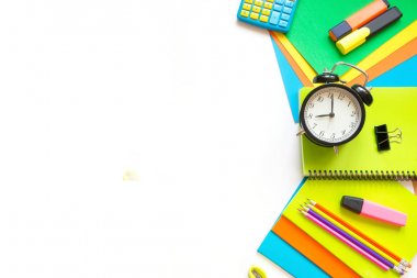 Renkli okul malzemeleri, kitap ve beyaza çalar saat. Üstten Görünüm, düz yatıyordu. Üstten Görünüm, kopya alanı.