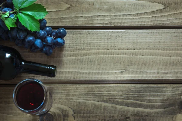 Botella abierta de vino tinto con copa, sacacorchos y uva madura sobre una tabla de madera. Copiar espacio y vista superior . —  Fotos de Stock