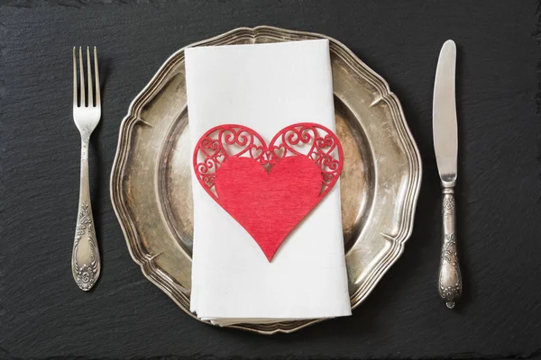 Świąteczne nakrycie stołu z rocznika naczynia, sztućce i serce dekoracje. — Zdjęcie stockowe