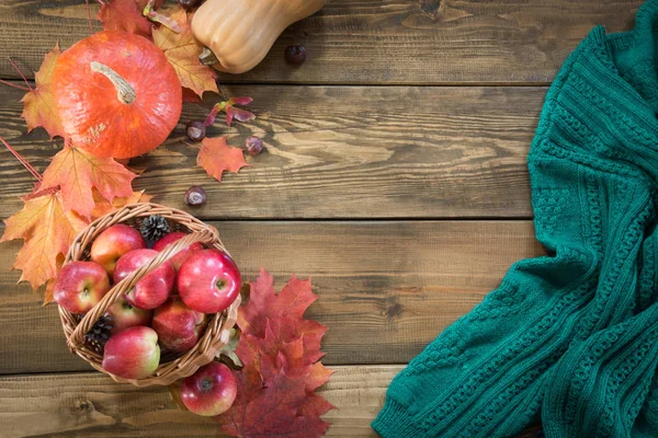 Natura morta d'autunno. Raccolta, zucca, mele in cesto, foglie autunnali colorate e Fotografia Stock