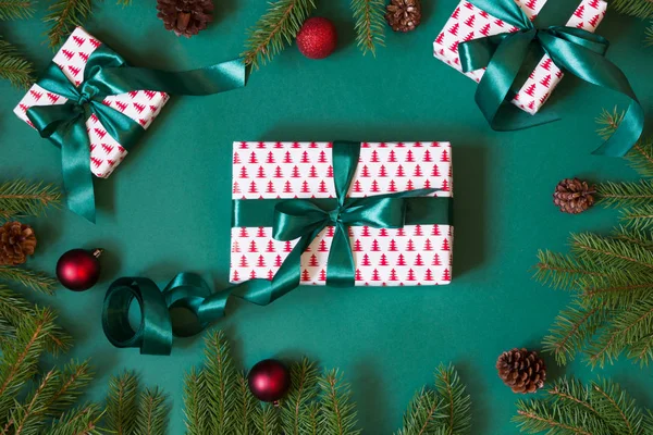 クリスマス giftboxes やプレゼントのラッピングは、赤い装飾が施された緑の紙、緑のリボンをデザインします。フラットが横たわっていた。トップ ビュー. — ストック写真