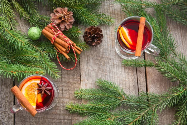 Vino caliente caliente caliente de Navidad con canela y árbol de Navidad en tablero de madera . — Foto de Stock