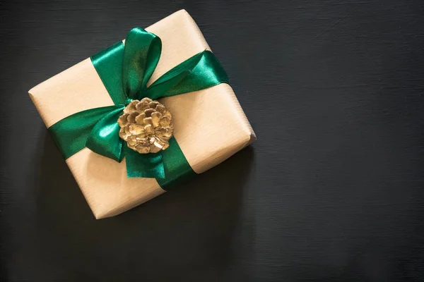 Geschenkverpackung in schwarzem Papier mit grünem Band auf schwarzem Papier. Ansicht von oben mit Kopierraum. — Stockfoto