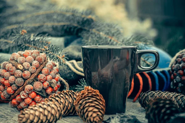 Чашка горячего чая на деревенском деревянном столе. Натюрморт из конусов, бечевок, патскниток, ель . — стоковое фото