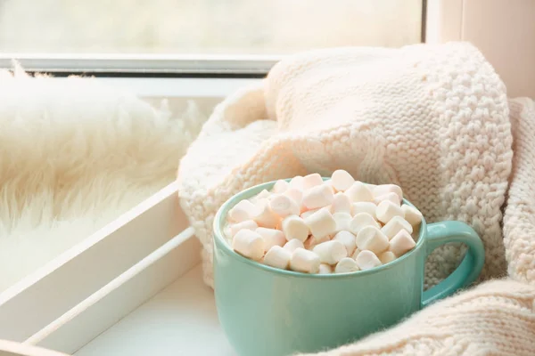 Μπλε φλυτζάνι της καυτής σοκολάτας με marshmallow σε windowsill με απορρίμματα γουνοδερμάτων για να χαλαρώσετε. Σαββατοκύριακο έννοια. Εγχώριο ύφος. — Φωτογραφία Αρχείου