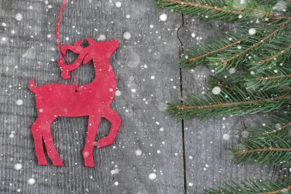 Decoración de venado de Navidad roja de madera sobre fondo de madera.Nieve dibujada . — Foto de Stock