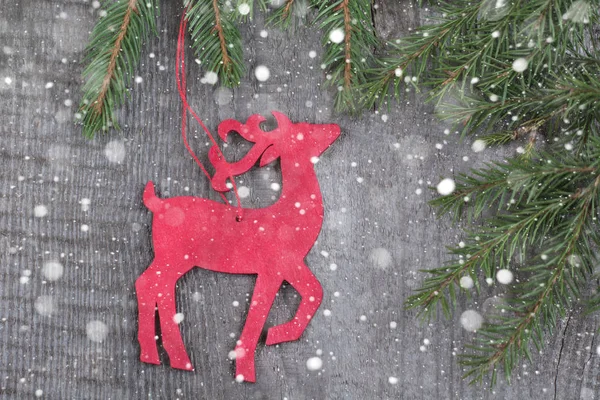 Decoración de venado de Navidad roja de madera sobre fondo de madera.Nieve dibujada . — Foto de Stock