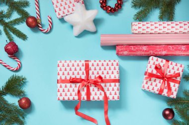 Noel yaratıcı hediye kutu kırmızı kurdele ile sarılmış ve mavi bir çalışma alanı oluşur. Düz yatıyordu. Üstten Görünüm.