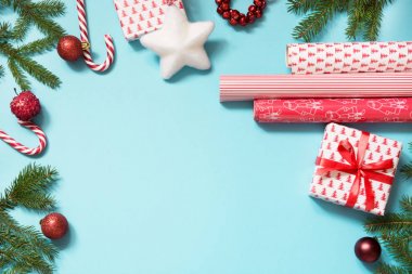 Noel yaratıcı hediye kutu kırmızı kurdele ile sarılmış ve mavi bir çalışma alanı oluşur. Düz yatıyordu. Üstten Görünüm.