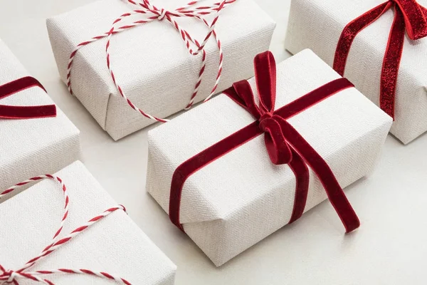 크리스마스 선물 상자 백서와 대리석 표면에 장식 붉은 밧줄 리본에 싸여 있다. 아이소메트릭. 클로즈업. — 스톡 사진