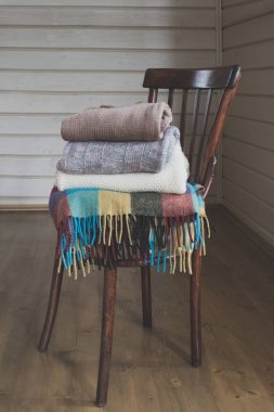 Rahat bir vintage ahşap sandalye üzerinde sıcak kazak yığını.