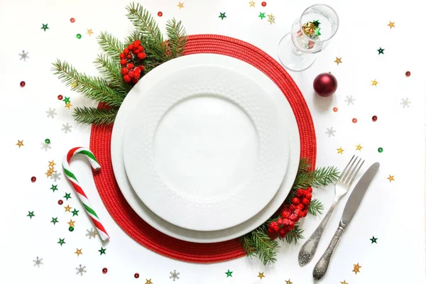 Ajuste de mesa de Navidad con vajilla blanca, platería y decoraciones rojas sobre fondo blanco. Vista superior . — Foto de Stock