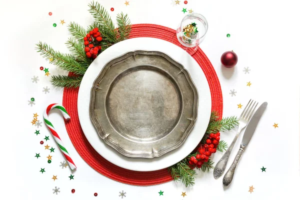 Ajuste de mesa de Navidad con vajilla blanca, platería y decoraciones rojas sobre fondo blanco. Vista superior . — Foto de Stock