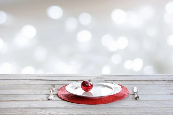 Tavolo bianco in legno con ambientazione natalizia, arredamento rosso su bokeh bianco astratto. Mock up Natale per il prodotto di visualizzazione . — Foto Stock