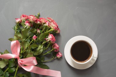 Buket pembe Gül ve gri arka plan üzerinde kahve. Üstten Görünüm. Sevgi ile romantik kartı.