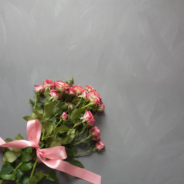 Ramo de rosas rosadas con lazo rosa sobre fondo gris. Vista superior. Copiar espacio . — Foto de Stock