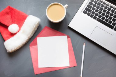 Ofis işyeri dizüstü, Noel Baba'nın kapağı, kahve, gri arka plan üzerinde aksesuarlar ile. Kopya alanı ile Üstten Görünüm.
