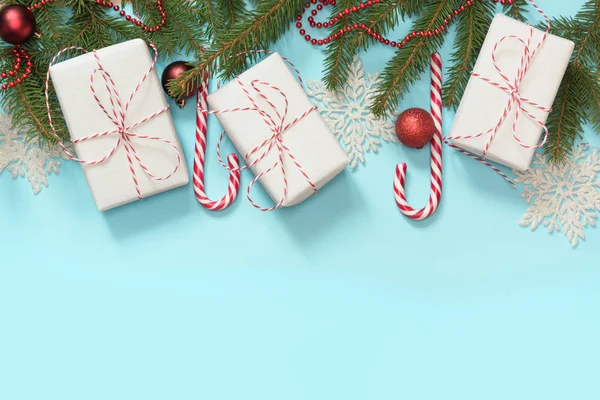 クリスマス白と赤の装飾、ギフト、キャンディの杖と創造の国境、雪片青い背景。フラットが横たわっていた。平面図です。コピー スペース. — ストック写真